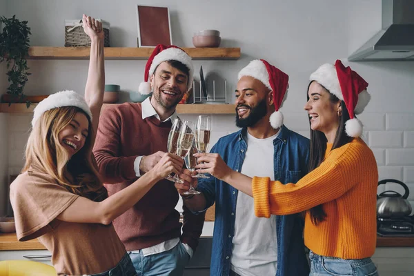 一群快乐的年轻人一边在家里庆祝圣诞节一边喝着香槟 — 图库照片