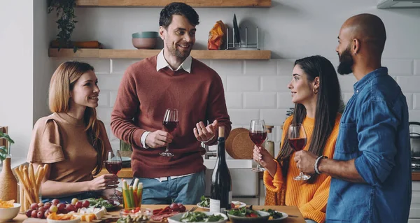 Jovens Bonitos Conversando Sorrindo Enquanto Desfrutam Jantar Casa Juntos — Fotografia de Stock