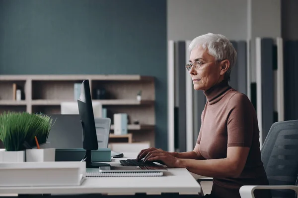 Pewna Siebie Starsza Bizneswoman Korzystająca Komputera Podczas Siedzenia Biurze — Zdjęcie stockowe