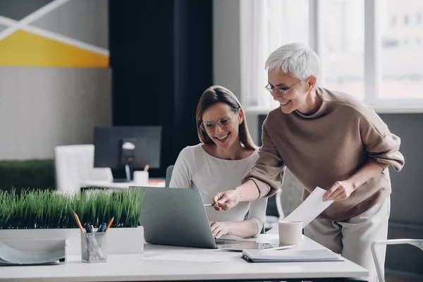 Zwei Selbstbewusste Geschäftsfrauen Blicken Auf Laptop Und Lächeln Während Sie — Stockfoto