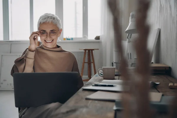 Pewna Siebie Starsza Bizneswoman Korzystająca Laptopa Uśmiechnięta Siedząc Miejscu Pracy — Zdjęcie stockowe
