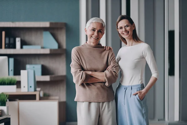 Two Confident Businesswomen Looking Camera Smiling While Standing Office Together — Stock Photo, Image