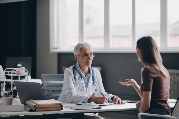 Dokter Wanita Yang Percaya Diri Mendengarkan Pasien Ketika Duduk Kantor — Stok Foto