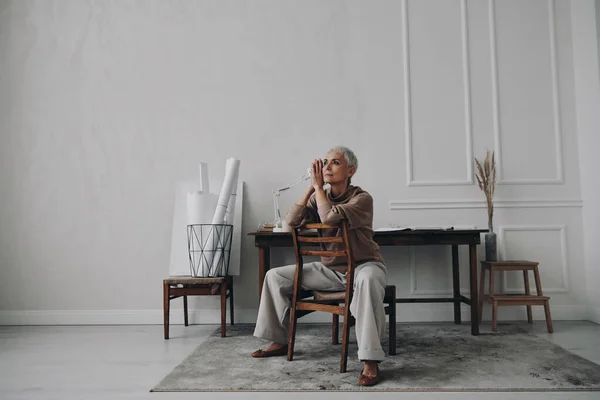 Schöne Seniorin Die Nachdenklich Ihrem Kreativen Arbeitsplatz Sitzt — Stockfoto