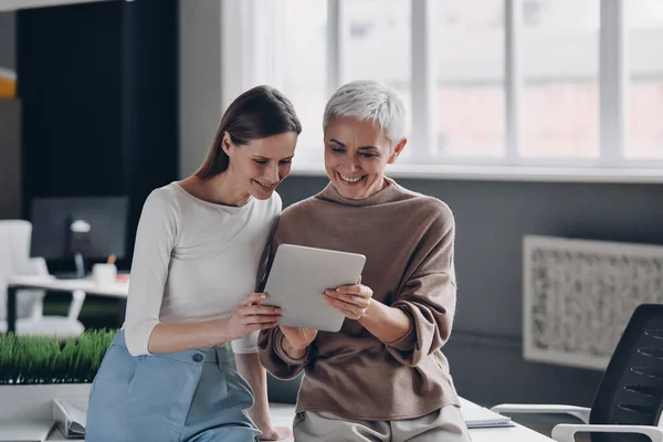 Zwei Geschäftsfrauen Blicken Auf Digitales Tablet Und Lächeln Während Ihrer — Stockfoto