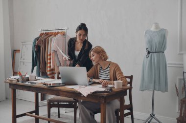 İki kendine güvenen moda tasarımcısı atölyede yeni koleksiyon üzerinde çalışıyor.