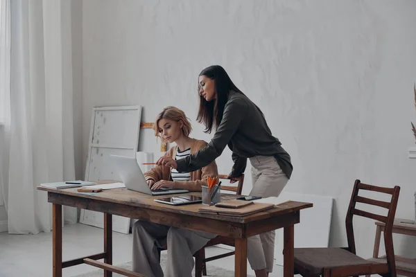Två Koncentrerade Affärskvinnor Använder Laptop Samtidigt Som Arbetar Tillsammans Det — Stockfoto