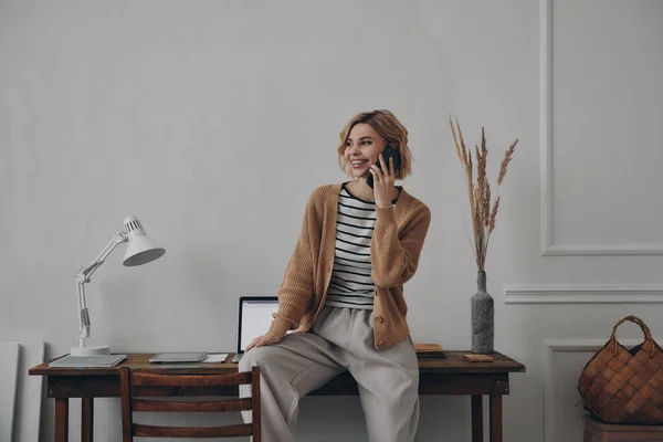 Mujer Joven Feliz Hablando Por Teléfono Móvil Mientras Está Sentada — Foto de Stock