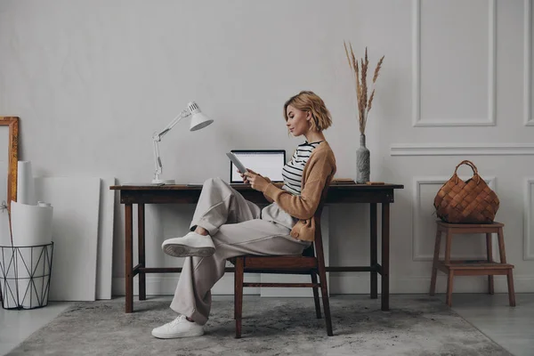 Mujer Joven Segura Usando Tableta Digital Mientras Está Sentada Lugar — Foto de Stock