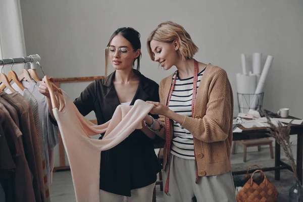 Dwie Piękne Projektantki Mody Badające Ubrania Podczas Pracy Warsztacie — Zdjęcie stockowe
