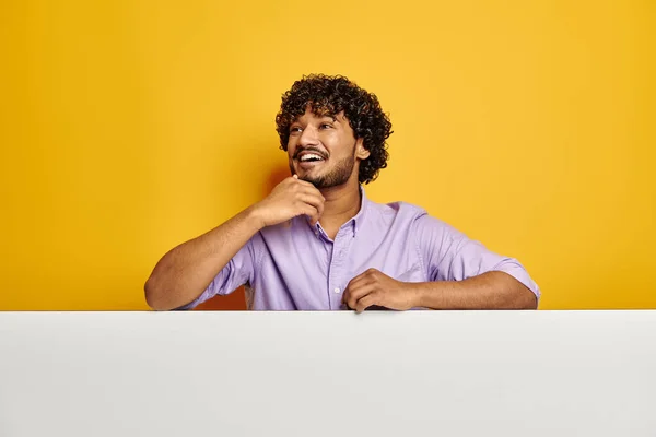 ハンサムなインド人男性はコピースペースで傾いて黄色の背景に笑みを浮かべて — ストック写真