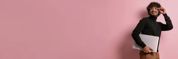 Радостный Индийский Мужчина Ноутбуком Регулировка Очков Розовом Фоне — стоковое фото