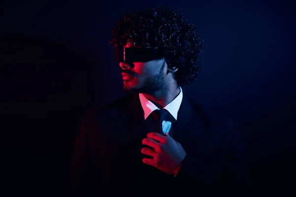 黒の背景に彼のネクタイを調整未来的なメガネで自信のビジネスマン — ストック写真