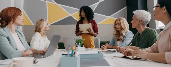 stock image Group of confident mature women having business meeting while sitting at the desk together