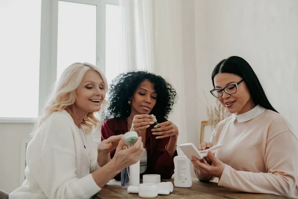 Three Happy Mature Women Discussing Beauty Treatments While Sitting Desk — Stock Photo, Image