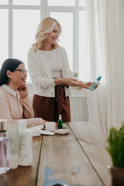 Two Confident Mature Women Smiling While Examining Beauty Products Together — Stock Photo, Image