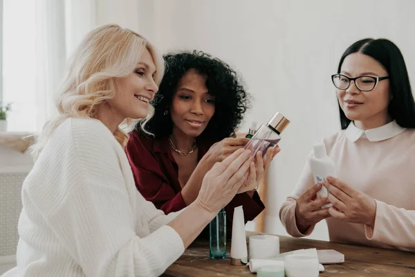 Három Érett Akik Kozmetikai Kezeléseket Vizsgálnak Miközben Együtt Ülnek Asztalnál — Stock Fotó