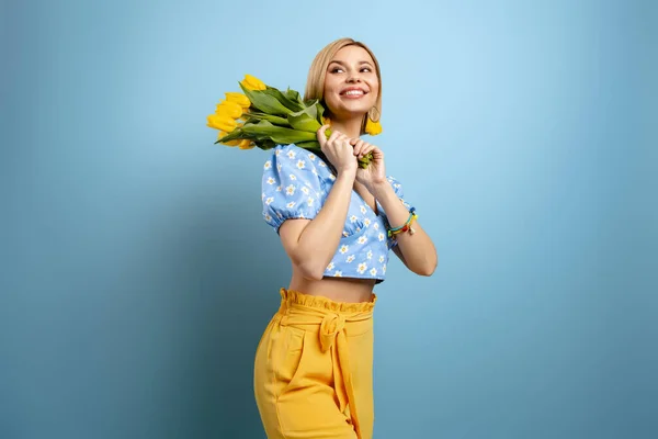 Joyeux Jeune Femme Portant Bouquet Tulipes Jaunes Sur Épaule Sur — Photo
