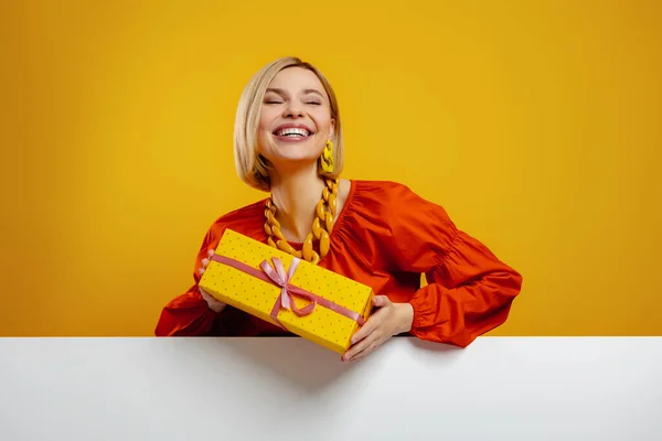 Joyful Jovem Segurando Uma Caixa Presente Sorrindo Contra Fundo Amarelo — Fotografia de Stock