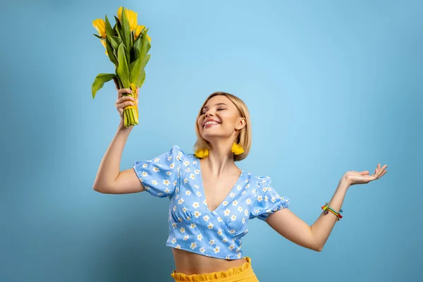 Mujer Joven Emocionada Sosteniendo Racimo Tulipanes Amarillos Sobre Fondo Azul —  Fotos de Stock
