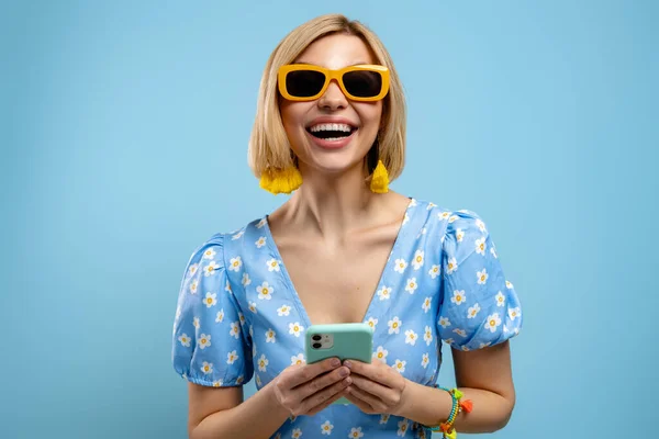 Opgewonden Jonge Vrouw Met Smart Phone Glimlachen Tegen Een Blauwe — Stockfoto
