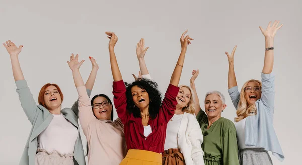 Multietnická Skupina Dospělých Žen Které Drží Ruce Zvednuté Usmívají Šedém — Stock fotografie