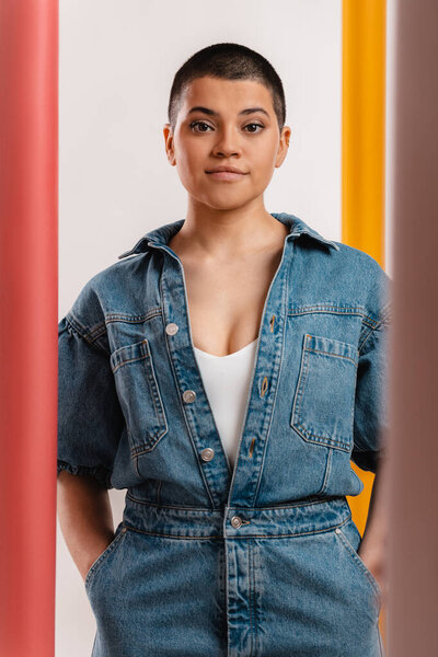Studio shot of stylish young short hair woman in denim clothes looking at camera