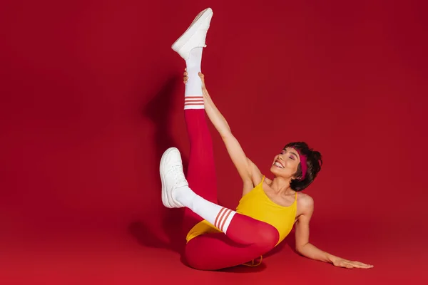 Verspielte Junge Fitte Frau Retro Sportkleidung Vor Rotem Hintergrund — Stockfoto