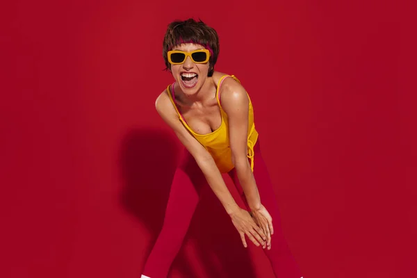 Захоплена Молода Жінка Ретро Стилі Спортивного Одягу Розважається Червоному Тлі — стокове фото