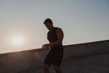 Spor elbiseli atletik bir genç sabah koşusunun tadını çıkarıyor.