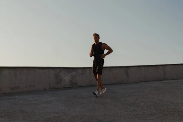 Spor Elbiseli Atletik Genç Adam Sabah Koşusunun Tadını Çıkarırken Yolda — Stok fotoğraf