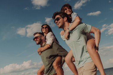 Kumsalda birlikte eğlenirken mutlu görünen iki genç çift.