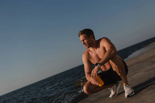 Knappe Mannelijke Atleet Die Water Fles Genieten Van Uitzicht Zee — Stockfoto