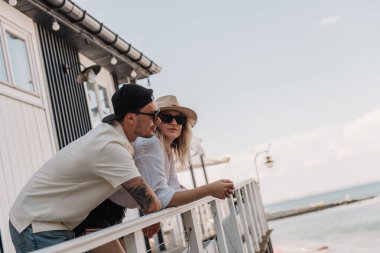 Genç romantik çift deniz manzaralı terasta sıcak bir yaz günü geçiriyorlar.