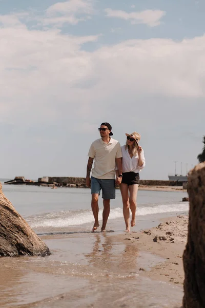 一緒にビーチを歩いている間に手を握る若いロマンチックなカップルの全長 — ストック写真