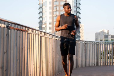 Spor kıyafetleri içinde kendine güvenen genç Afrikalı sabah koşusunun tadını çıkarıyor.