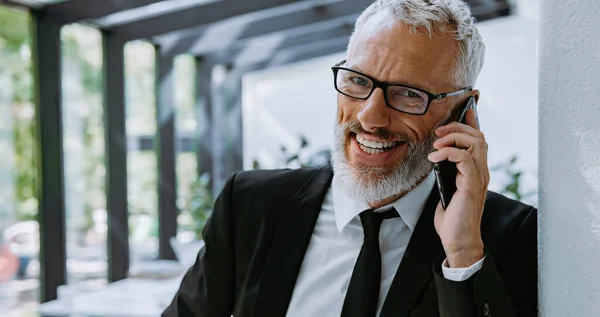 Happy Mature Businessman Talking Mobile Phone While Standing Modern Office — Stock Photo, Image