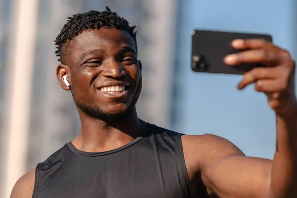 快乐的年轻非洲运动员在户外用智能手机和微笑进行视频通话 — 图库照片