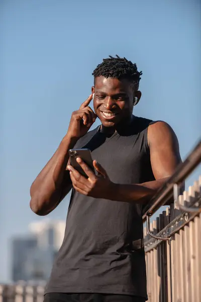 Veselý Africký Atlet Pomocí Chytrého Telefonu Nastavení Sluchátek Při Přípravě — Stock fotografie