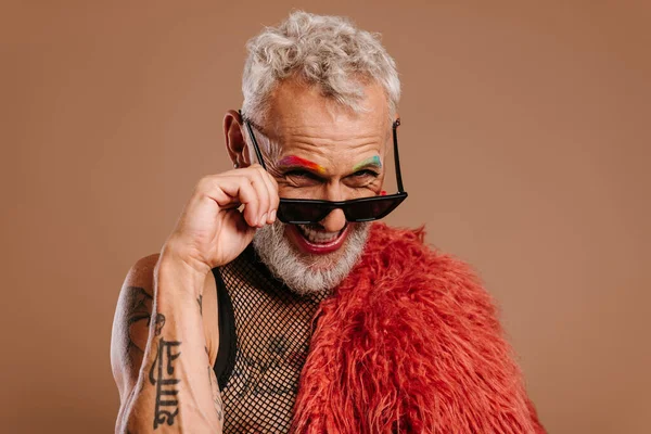 Stylový Zralý Gay Muž Barevným Obočím Upravující Brýle Usmívající Hnědém — Stock fotografie