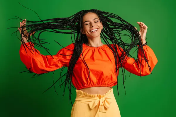 Радісна Молода Жінка Дредлоками Танцює Посміхається Зеленому Фоні — стокове фото