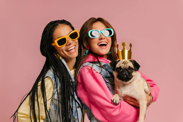 Two Fashionable Young Women Trendy Glasses Carrying Cute Pug Dog — Stock Photo, Image