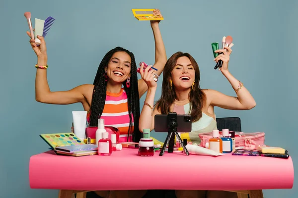 Dos Influencers Femeninas Felices Mostrando Varios Productos Belleza Mientras Transmiten —  Fotos de Stock
