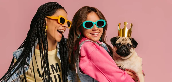 Two Joyful Young Women Trendy Glasses Carrying Cute Pug Dog — Stock Photo, Image