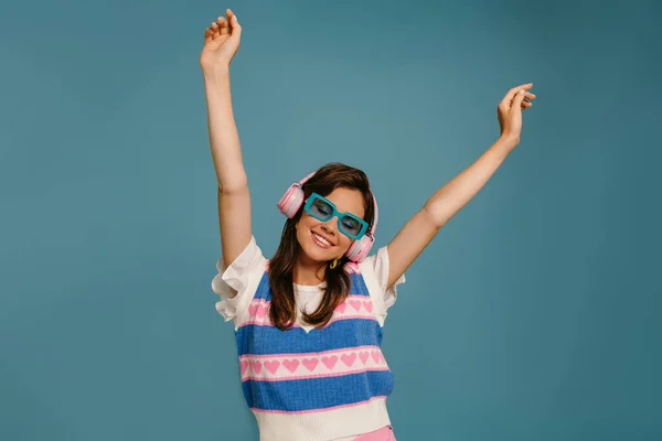 Mavi Arka Planda Dans Ederken Kulaklıklı Modaya Uygun Gözlüklü Mutlu — Stok fotoğraf