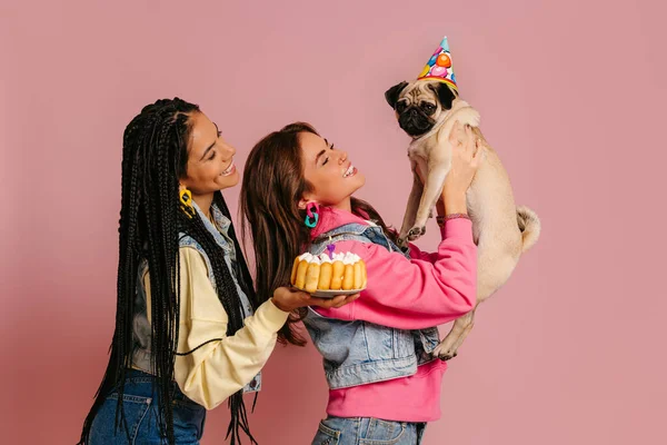 Two Happy Young Women Bonding While Carrying Cute Pug Dog — Stock Photo, Image