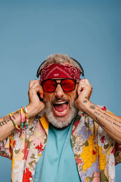 Hipster Senior Man Adjusting Headphones Shouting While Listening Music Blue — Stock Photo, Image