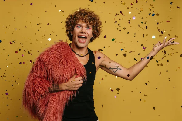 Feliz Joven Gay Hombre Usando Mullido Abrigo Lanzando Colorido Confeti —  Fotos de Stock
