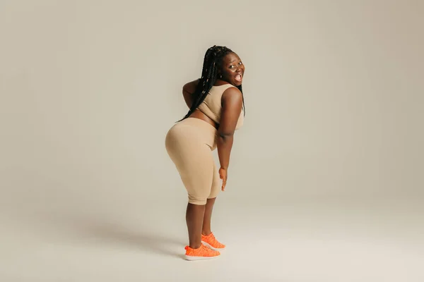 Bela Mulher Africana Curvilínea Sportswear Olhando Feliz Confiante Enquanto Fundo — Fotografia de Stock
