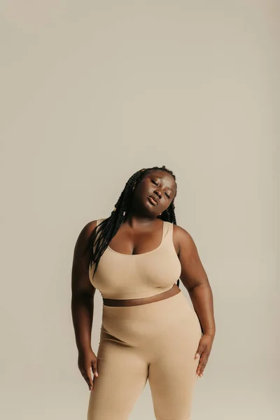 stock image Confident African plus size woman in underwear radiating self-love while standing on studio background